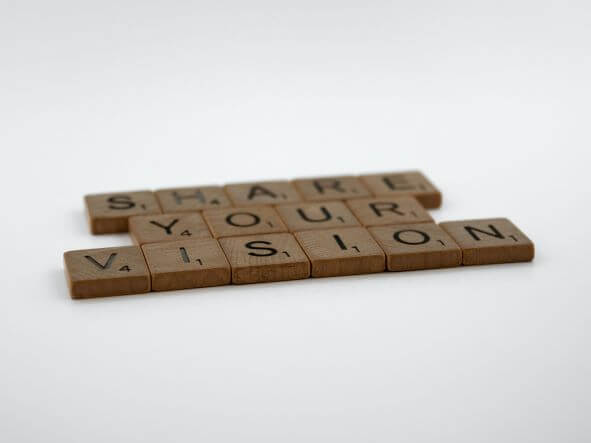 Wooden Blocks with letters arranged to say share your Vision. arr